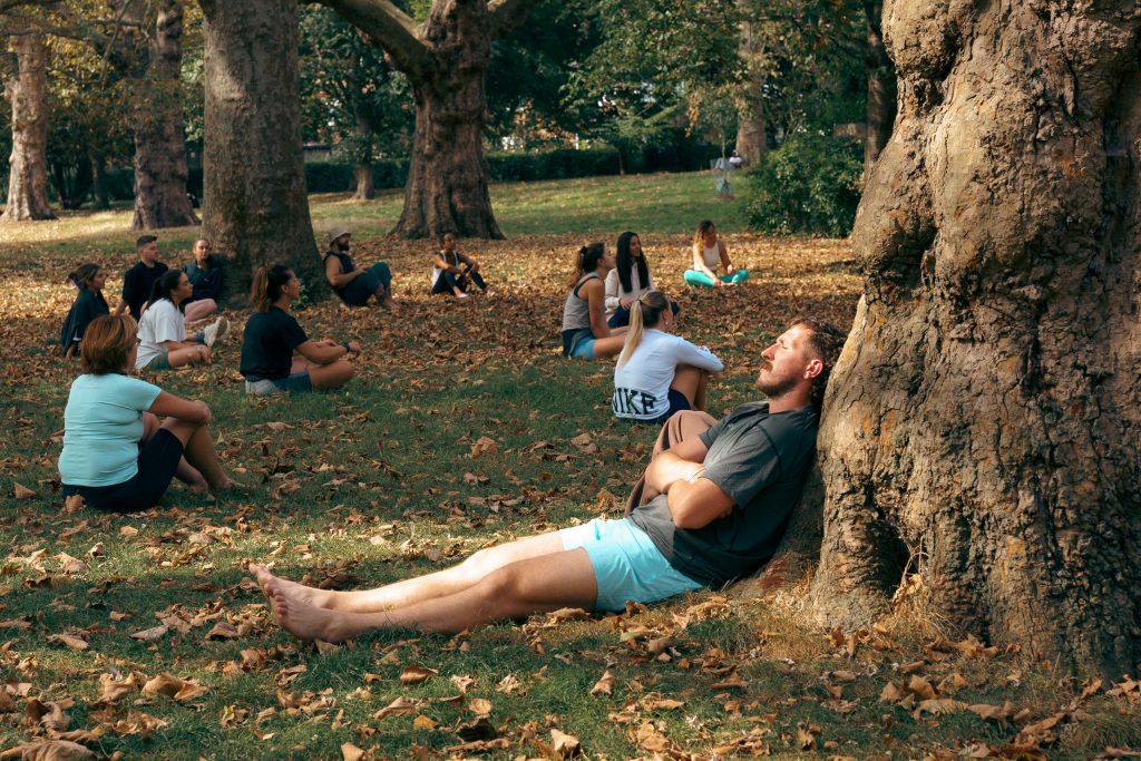 image of a wellbeing attendee relaxing under a tree at the mindful elements team day experience